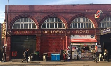 Red-tiled exterior of underground station. Signage on the station reads: 
'Exit - Holloway - Road'
