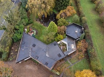 Aerial view of a modern house, including a detached garage and gardens
