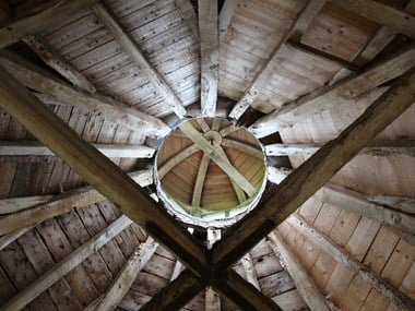 A close-up of an interior ceiling structure featuring wooden beams