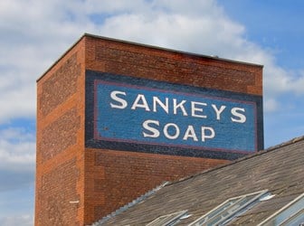 A blue and white sign reading 'Sankey's Soap' on the side of a brick building.