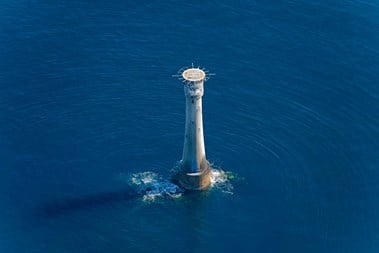 Aerial view of lighthouse in the middle of the sea